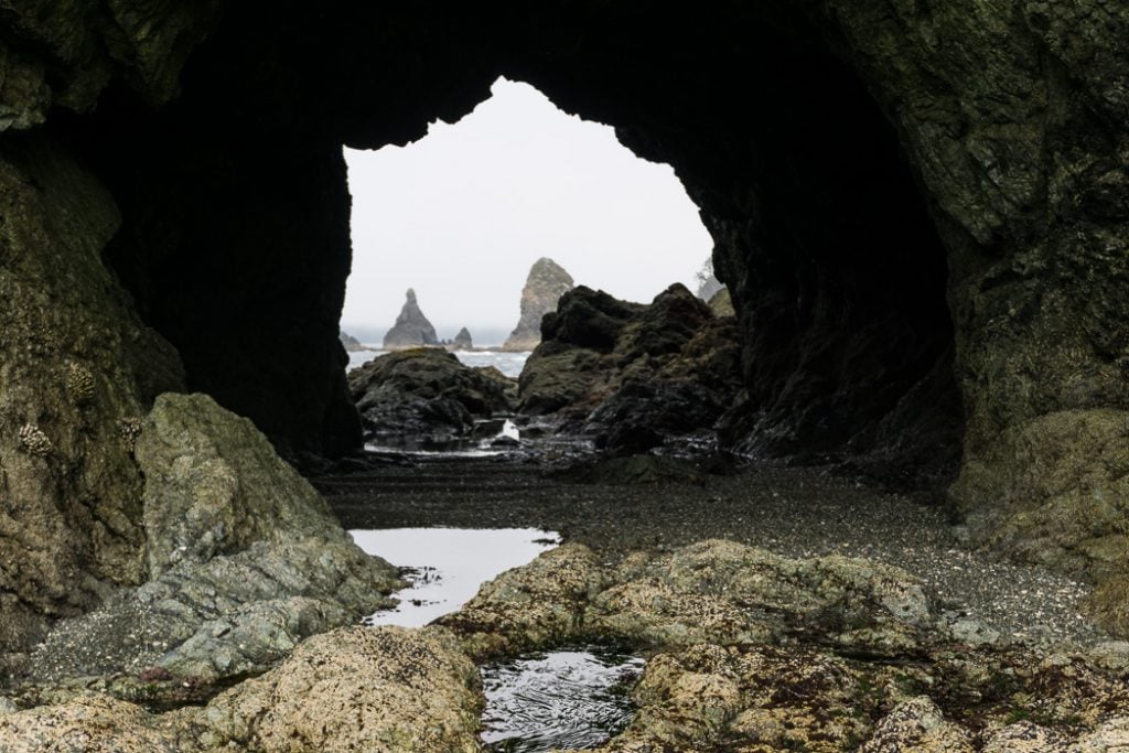 Looking through an arch at Point of the Arches at Shi Shi Beach. A complete guide to hiking and camping at Shi Shi Beach.