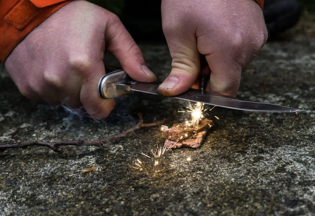 Learning to strike a ferro rod in a wilderness survival course with Megan Hanacek and Carleigh Fairchild