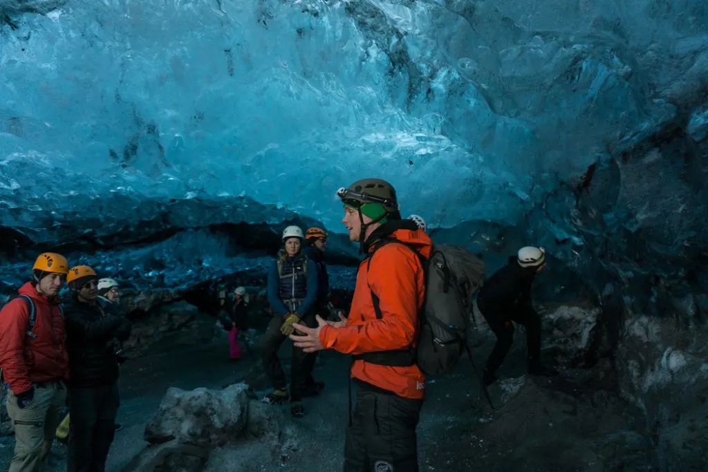 Ice cave tour guide inside an ice cave in Iceland. The Ultimate Guide to Ice Caves in Iceland: Everything you ever needed to know about visiting ice caves in Iceland. Find out how to go INSIDE the Crystal Cave glacier ice cave to see the blue ice.