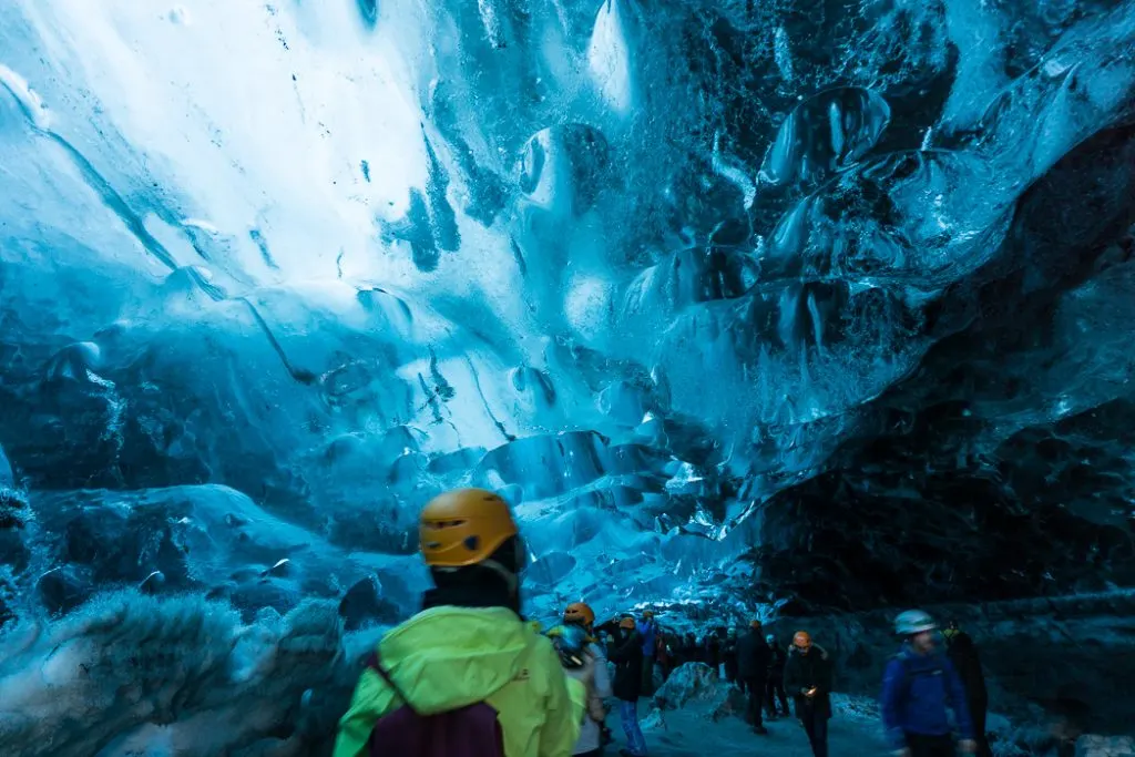 Tour groups inside an ice cave in Iceland. The Ultimate Guide to Ice Caves in Iceland: Everything you ever needed to know about visiting ice caves in Iceland. Find out how to go INSIDE the Crystal Cave glacier ice cave to see the blue ice.