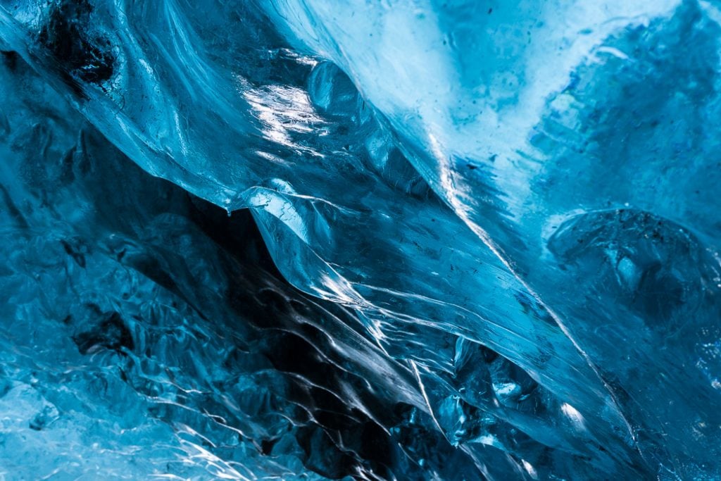 Close-up of the blue ice formations in an ice cave in Iceland .The Ultimate Guide to Ice Caves in Iceland: Everything you ever needed to know about visiting ice caves in Iceland. Find out how to go INSIDE the Crystal Cave glacier ice cave to see the blue ice.