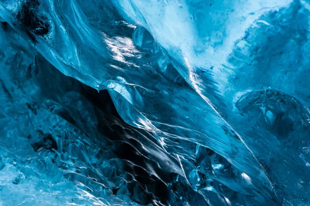 Close-up of the blue ice formations in an ice cave in Iceland .The Ultimate Guide to Ice Caves in Iceland: Everything you ever needed to know about visiting ice caves in Iceland. Find out how to go INSIDE the Crystal Cave glacier ice cave to see the blue ice.