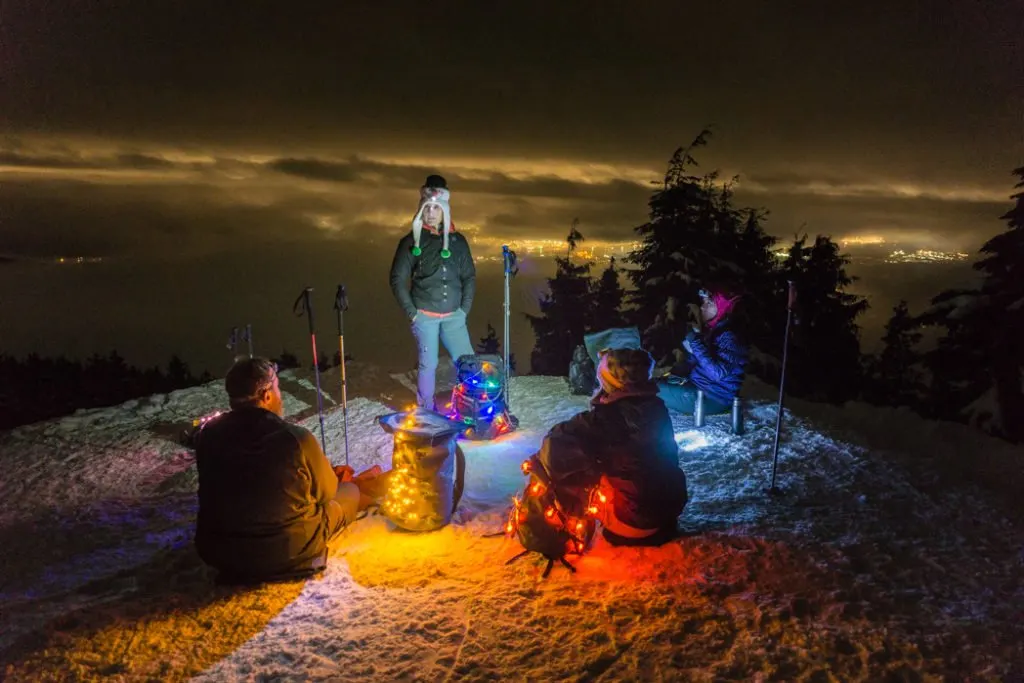 Hikers on a mountain top at night. Hiking in the dark is one way to avoid crowded trails.