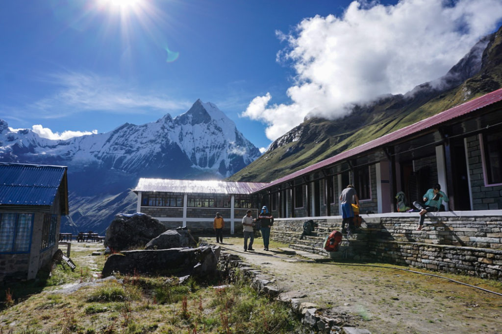 Trekkers pack their bags outside the teahouse at Annapurna Base Camp. What to pack for the Annapurna Base Camp Trek in Nepal.