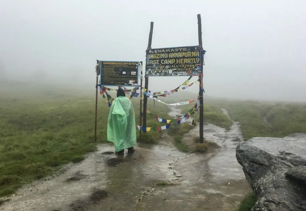 Nepali guide wearing a plastic sheet as a rain cover at Annapurna Base Camp. What to pack for the Annapurna Base Camp Trek in Nepal.