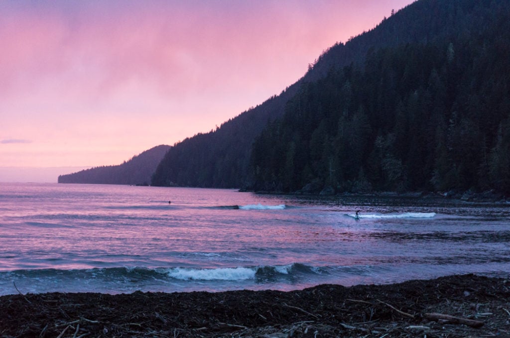 A surfer at sunset at the Pacheedaht Campground in Port Renfrew. It makes a great place to camp on a road trip on the Pacific Marine Circle Route on Vancouver Island.