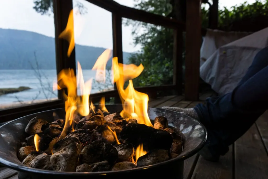 Enjoying the fire pit on the patio of a cabin at Wind Renfrew, a great place to overnight on a road trip on the Pacific Marine Circle Route on Vancouver Island.