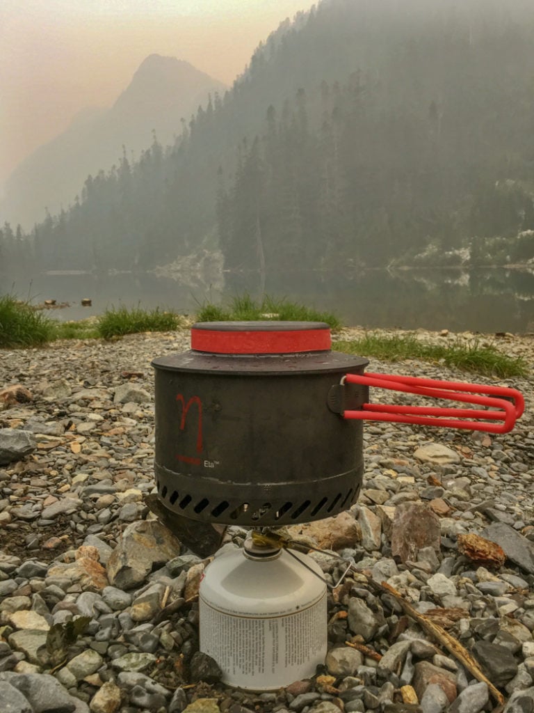 Camp stove at a foggy lake. How to choose backpacking meals.