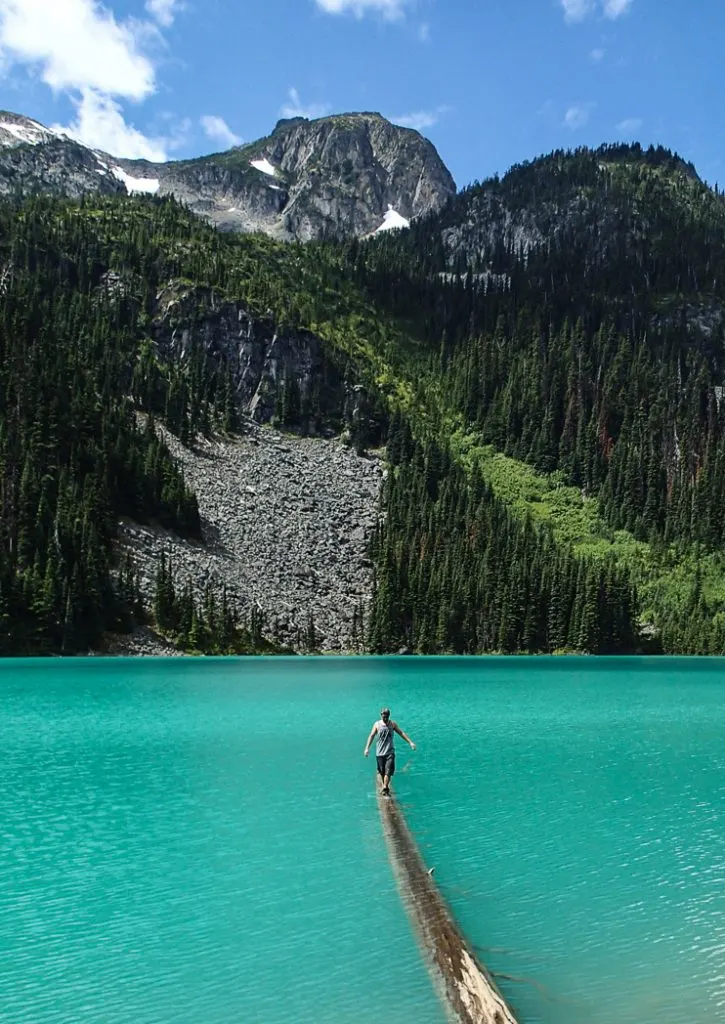 A hiker balances on a log at Joffre Lakes near Vancouver