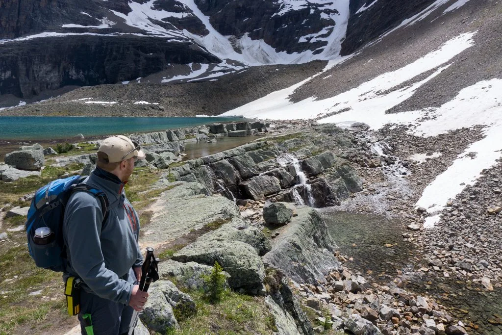 A hiker wearing bear spray in a hip holster near Lake O'Hara. You should pack bear spray for your Lake O'Hara trip.