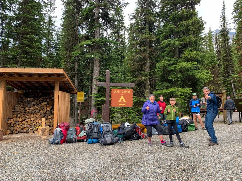 People and luggage waiting for the bus at the Lake O'Hara campground