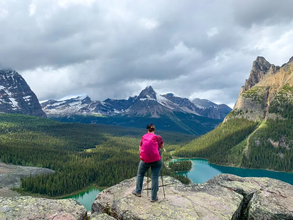 A hiker wearing a backpack with a rain cover on it at Opabin Prospect near Lake O'Hara in Yoho National Park. A raincover is an essential item on any Lake O'Hara packing list.