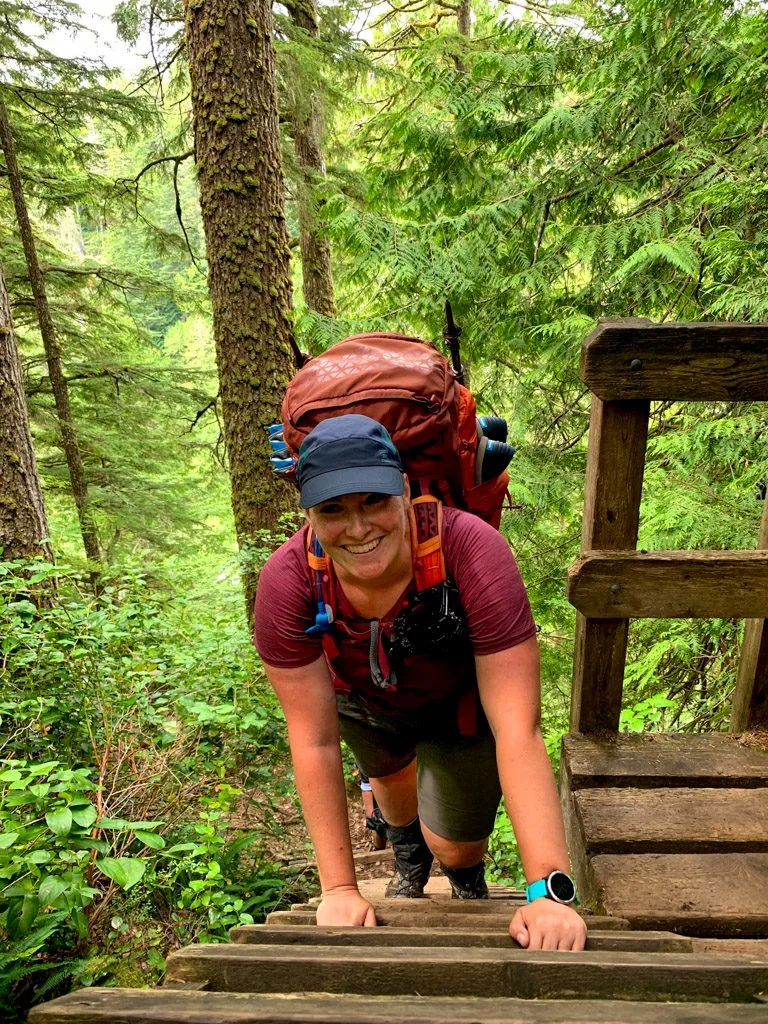 A hiker climbs a ladder on the West Coast Trail