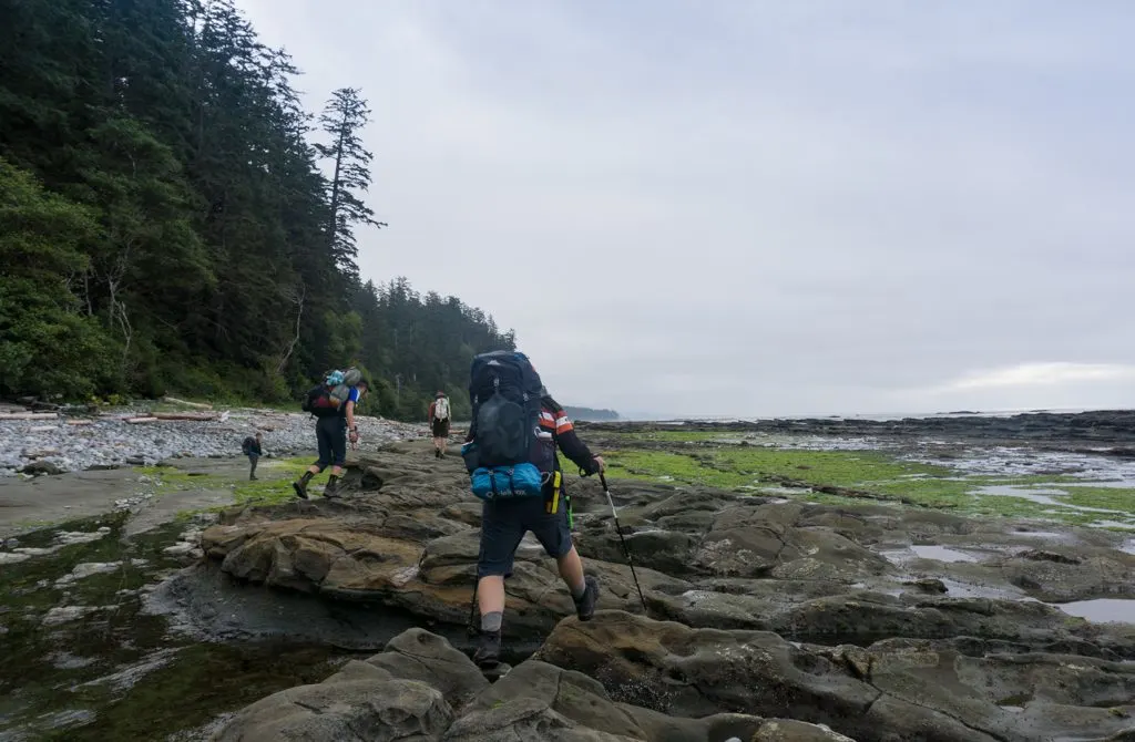 Hikers walking on the rocky coastal shelf near Michigan Creek on the West Coast Trail