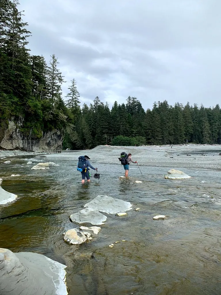 Hikers wade across the mouth of Walbran Creek on the West Coast Trail