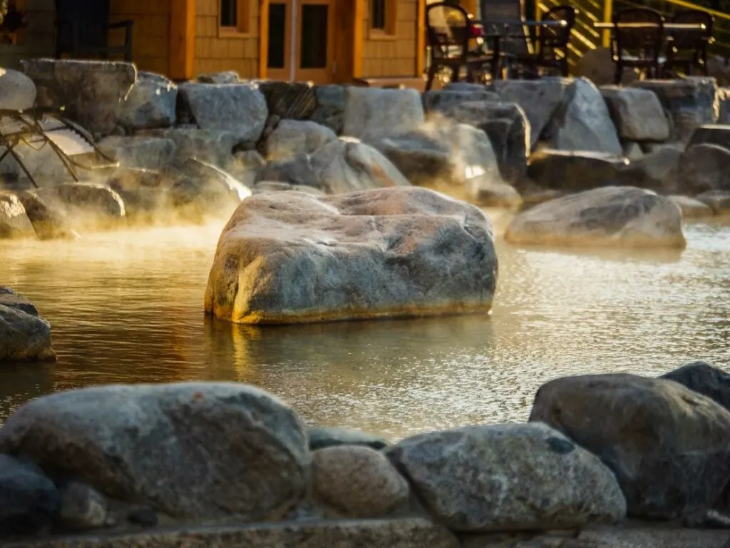 Steam rises off a pool surrounded by rocks at Eclipse Nordic Hot Springs