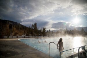 A woman walks into a steaming pool at Fairmont Hot Springs