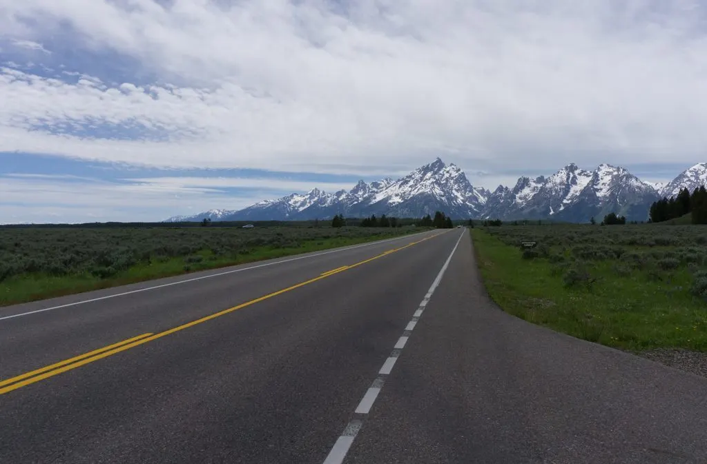 A road in Grand Teton National Park with mountains in the background