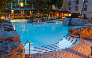 The hot springs pools at Harrison Hot Springs Resort at dusk with lights arond the