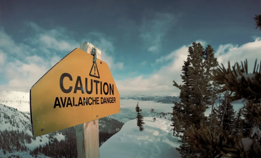 A sign warns of avalanche danger on a snowy mountain