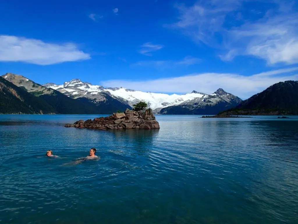 Hikers swimming in Garibaldi Lake, one of the best hikes near Whistler, BC