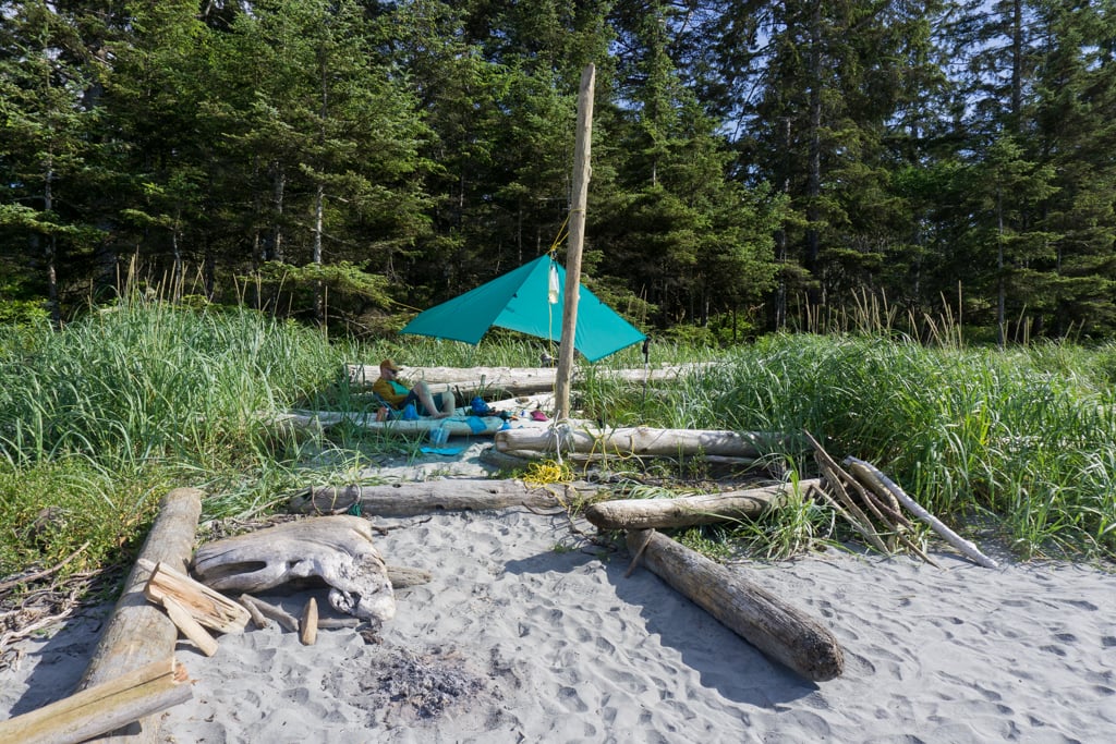 Campers under a tarp on a beach on Northern Vancouver Island