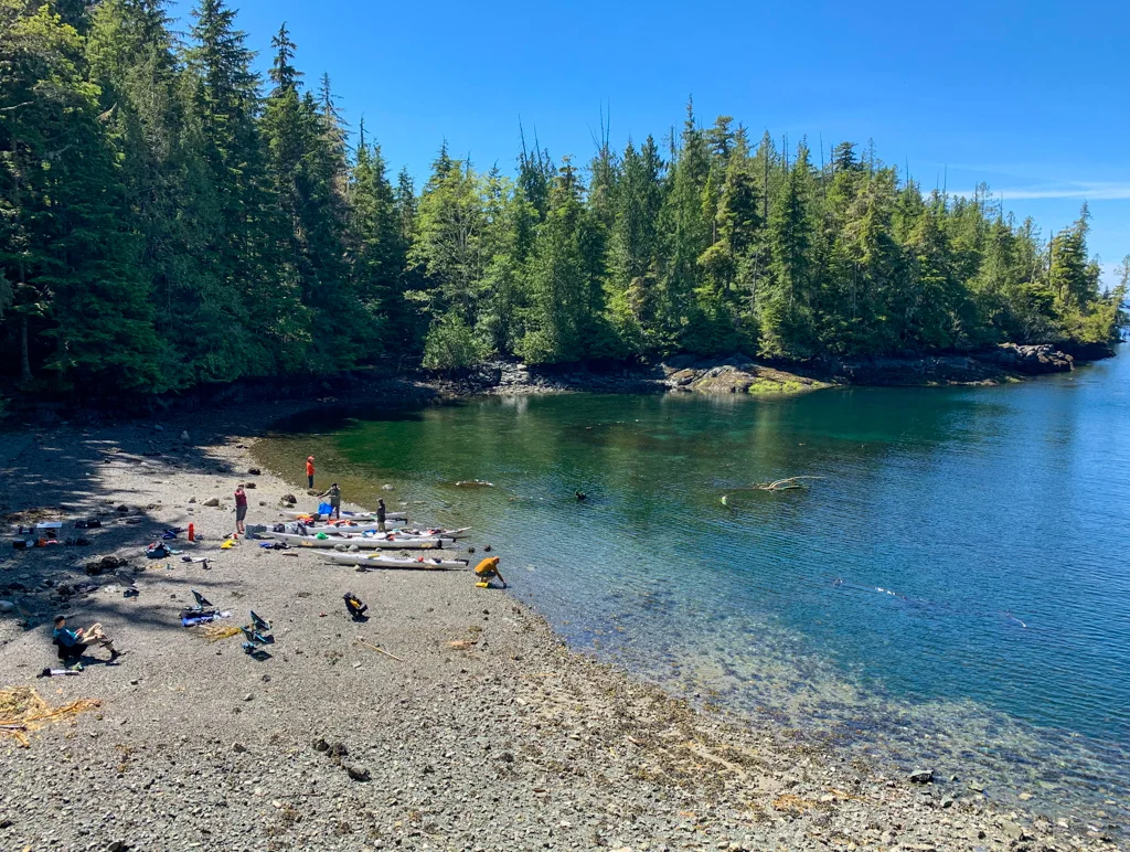 A group of kayakers relax on the beach in the Johnstone Strait