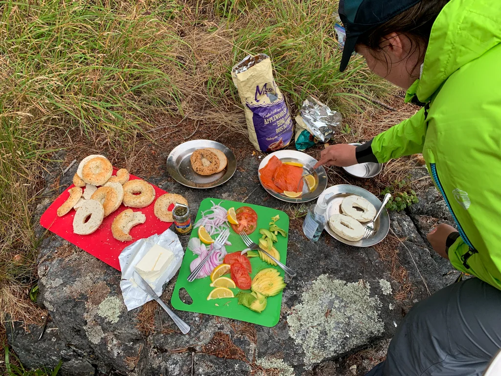 A kayaker makes a bagel sandwich on a guided kayak tour in the Johnstone Strait