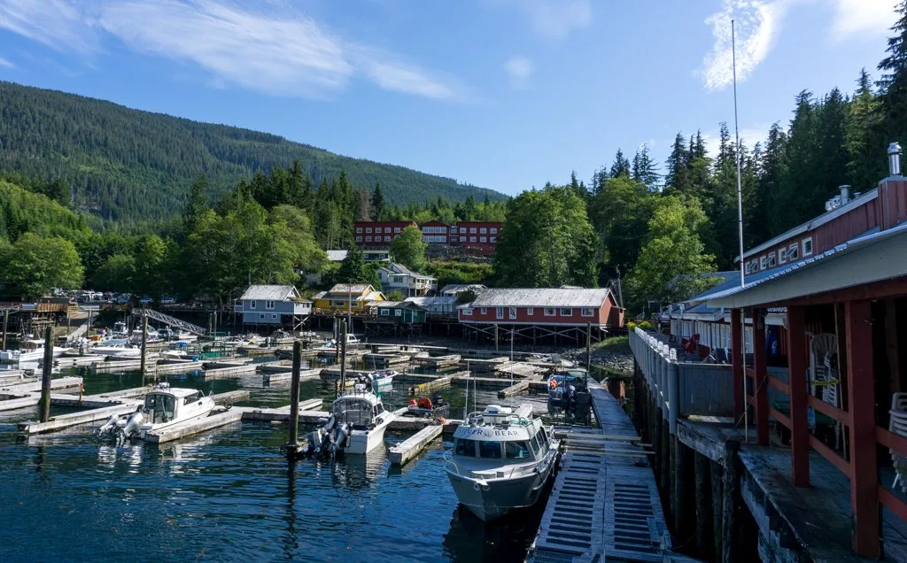 Buildings along the boardwalk and boats in the marina in Telegraph Cove, BC