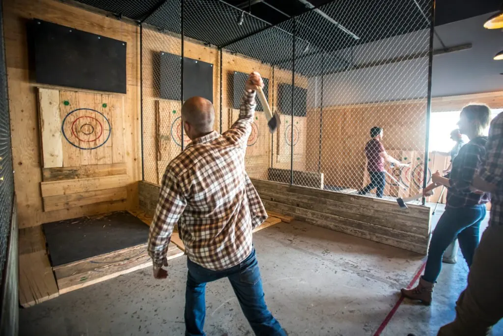 A man throwing an axe at a target at Forged Axe Throwing