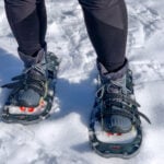 Close up of a a person wearing insulated hiking boots with snowshoes. The best boots for snowshoeing