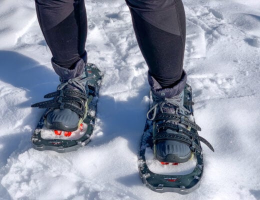 Close up of a a person wearing insulated hiking boots with snowshoes. The best boots for snowshoeing