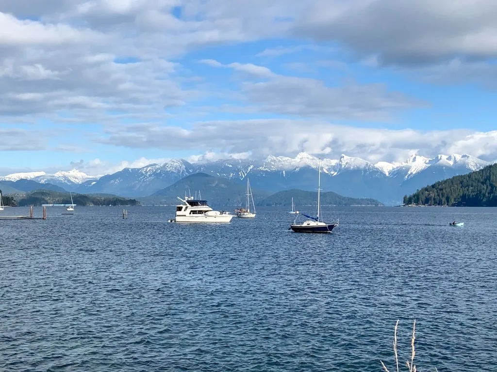 Boats in Gibsons, BC with a view of the Howe Sound Mountains behind