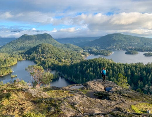 A woman stands on a rocky outcropping on Pender Hill - one of the best hikes on the Sunshine Coast, BC
