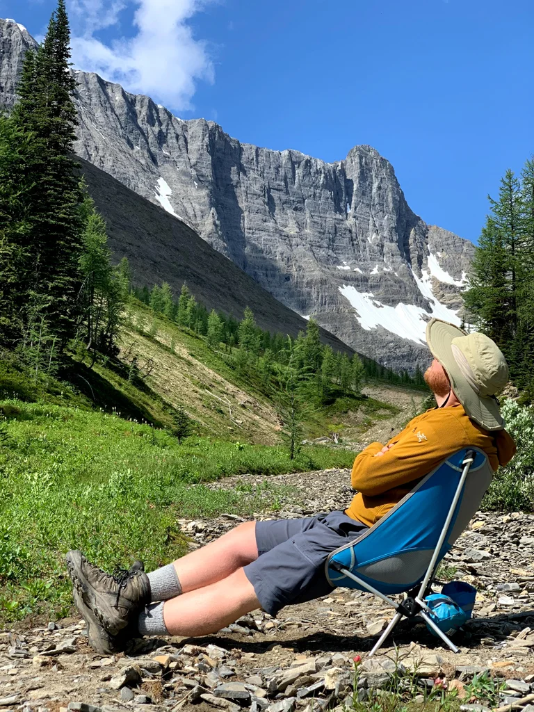 A man sits in a chair at Tumbling Pass on the Rockwall Trail