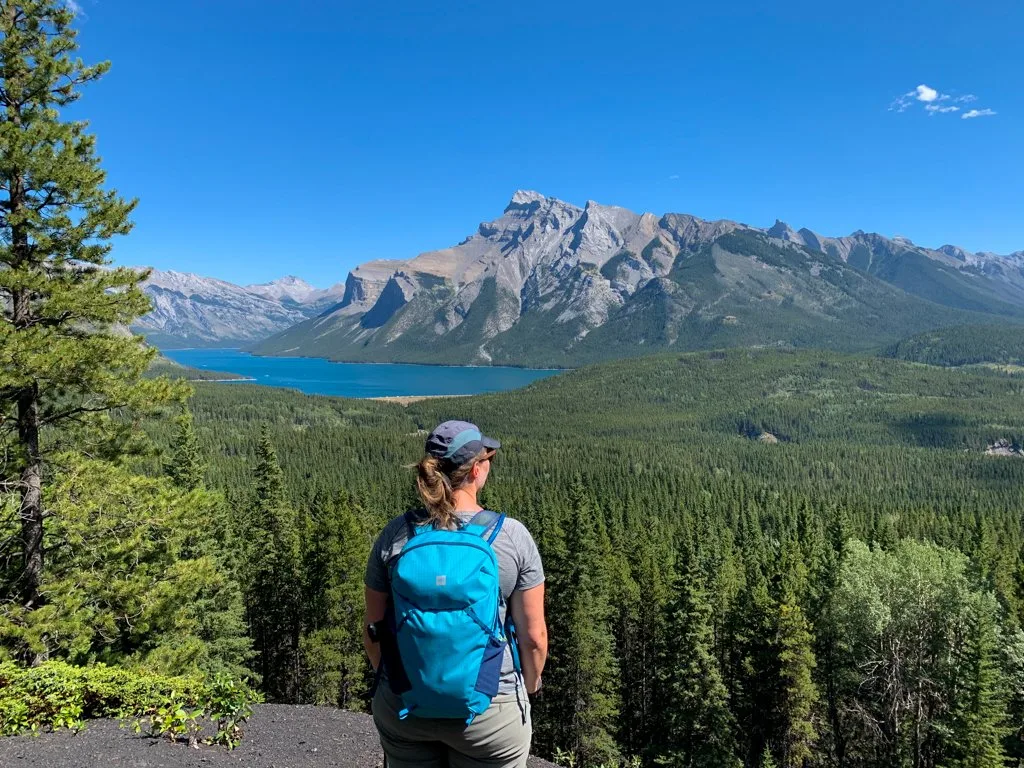 A woman stands at a viewpoint about Lake Minnewanka in Banff National Park
