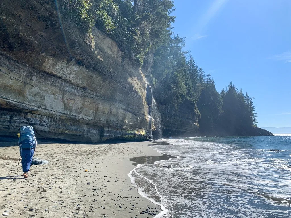 A hiker near the waterfall at Mystic Beach on the Juan de Fuca Trail on Vancouver Island