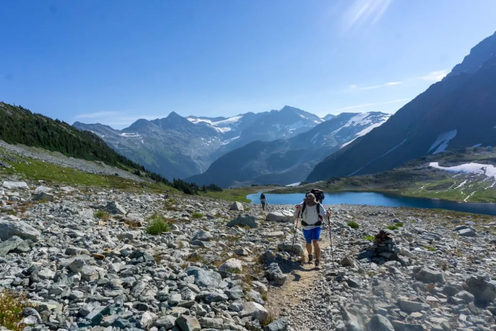 A man wearing a large backpack at Russet Lake near Whistler