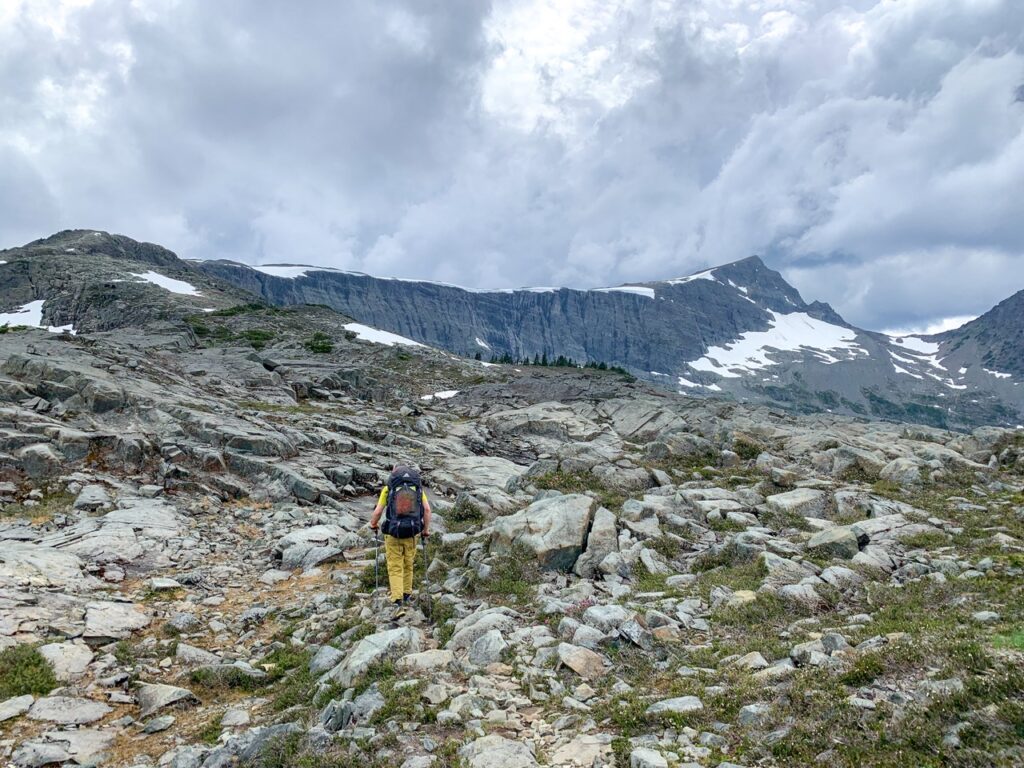 A hiker walks through rocks on the summit ridge of Mount Albert Edward