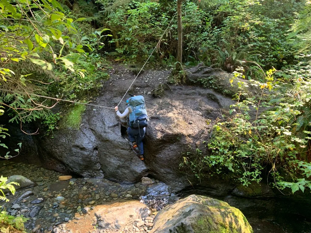 Using a rope to cross a tricky creek on the Juan de Fuca Trail