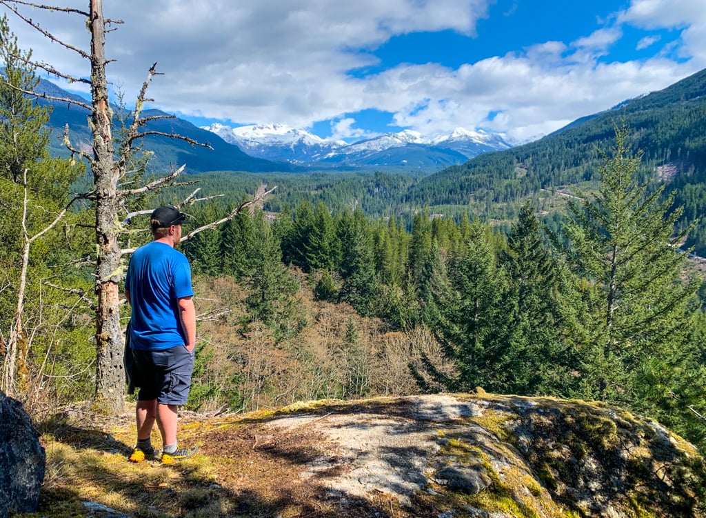 A hiker admires the view of Mamquam Mountain from the Viewpoint Trail on Mount Crumpit