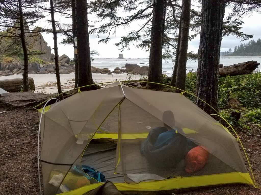 A boy inside a backpacking tent at Toleak Point in Olympic National Park