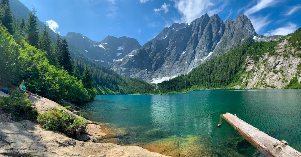 A green lake at the base of a mountain. Get hiking slang definitions in this dictionary for hikers.