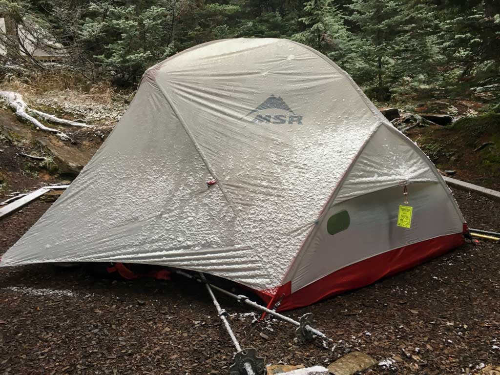 Tent with snow on it. Learn how to keep warm in a tent