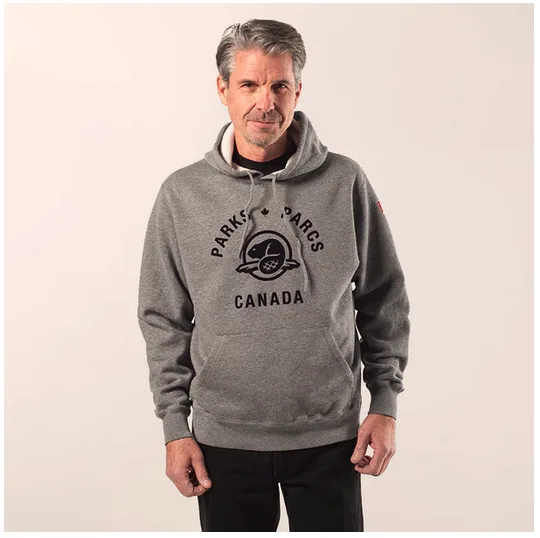 A man wearing a grey cotton hoody with a large Parks Canada logo on the front. It makes a great gift for national parks of canada lovers