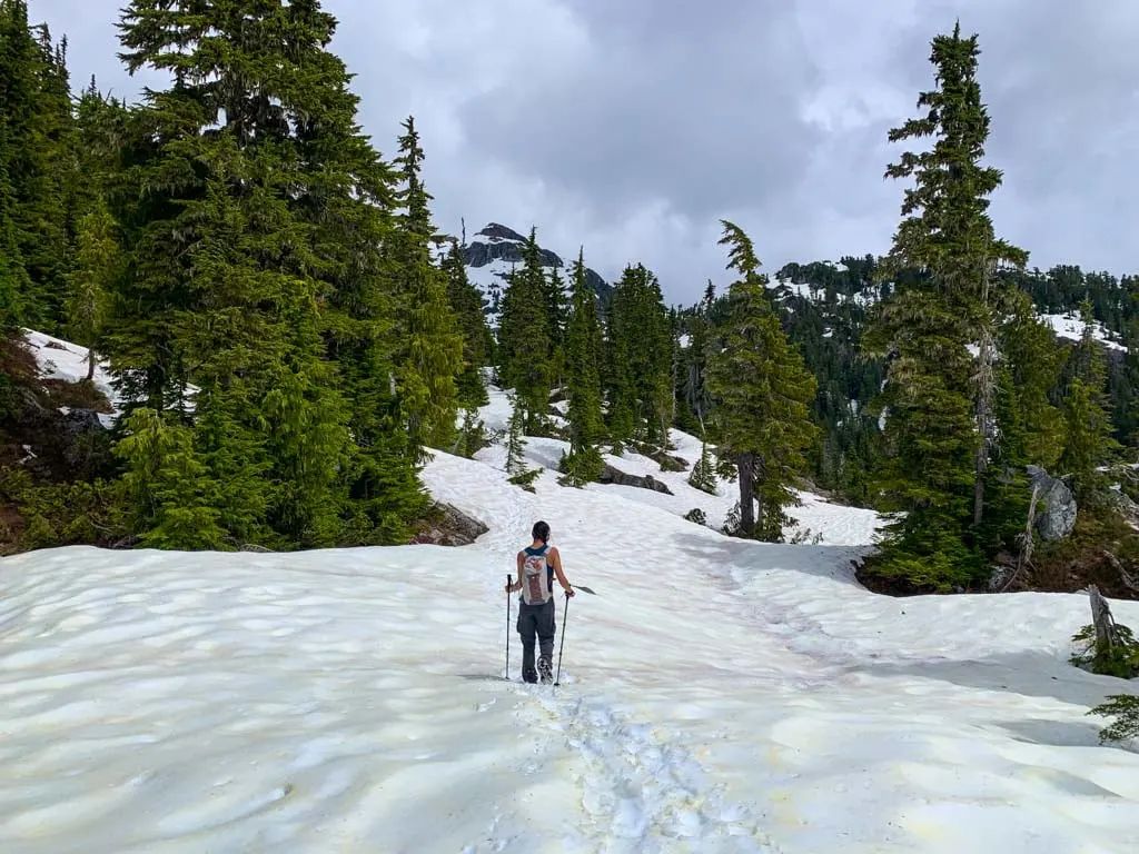 A hiker walks through snow near Love Lake