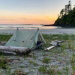 A tent on the beach at sunset on the Tatchu Trail, a wilderness backpacking trip on the Tatchu Peninsula on the west side of Vancouver Island, BC