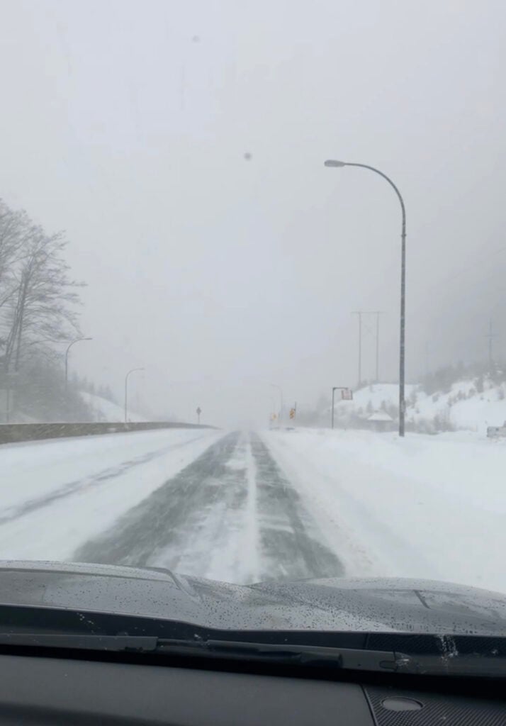 Looking through a car window onto the Sea to Sky Highway during a snow storm