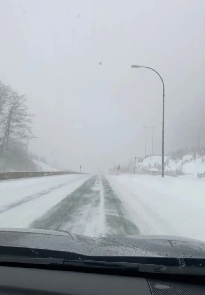 Looking through a car window onto the Sea to Sky Highway during a snow storm
