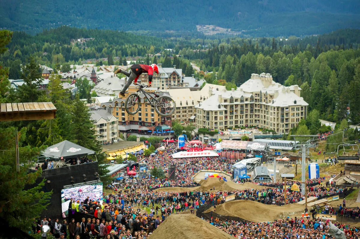 Spectators watch a mountain biker hit a jump at the Crankworx festival